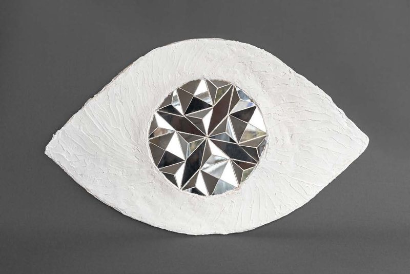 Fraction, 2024. Plaster eye form with a faceted mirror disc as the pupil