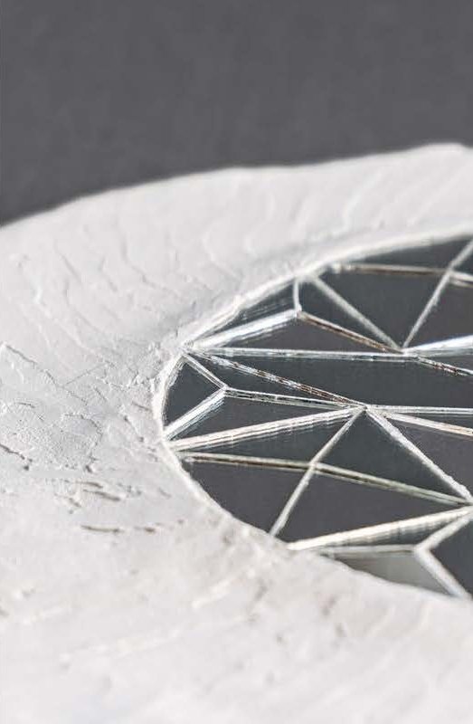 Fraction (2024), plaster eye form with a faceted mirror disc as the pupil, view 2