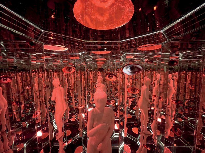 Peep Box, 2023. Mirrored infinity chamber lit red, seen through a peephole